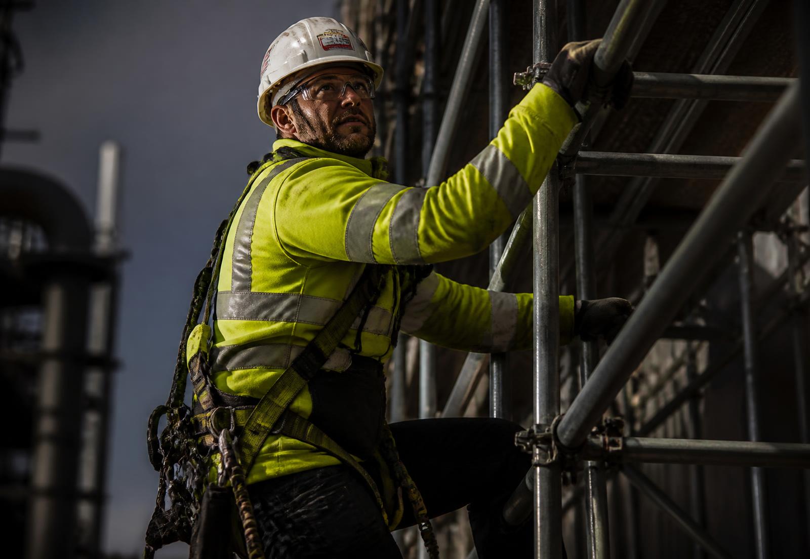 Certified scaffold worker climbing tube-and-coupler scaffolding